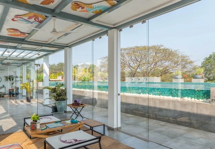 Bright glass-walled lounge opening onto the community pool