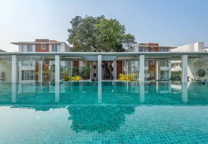 Shared community pool and glass-walled pavilion at the Basilius Hospitality properties